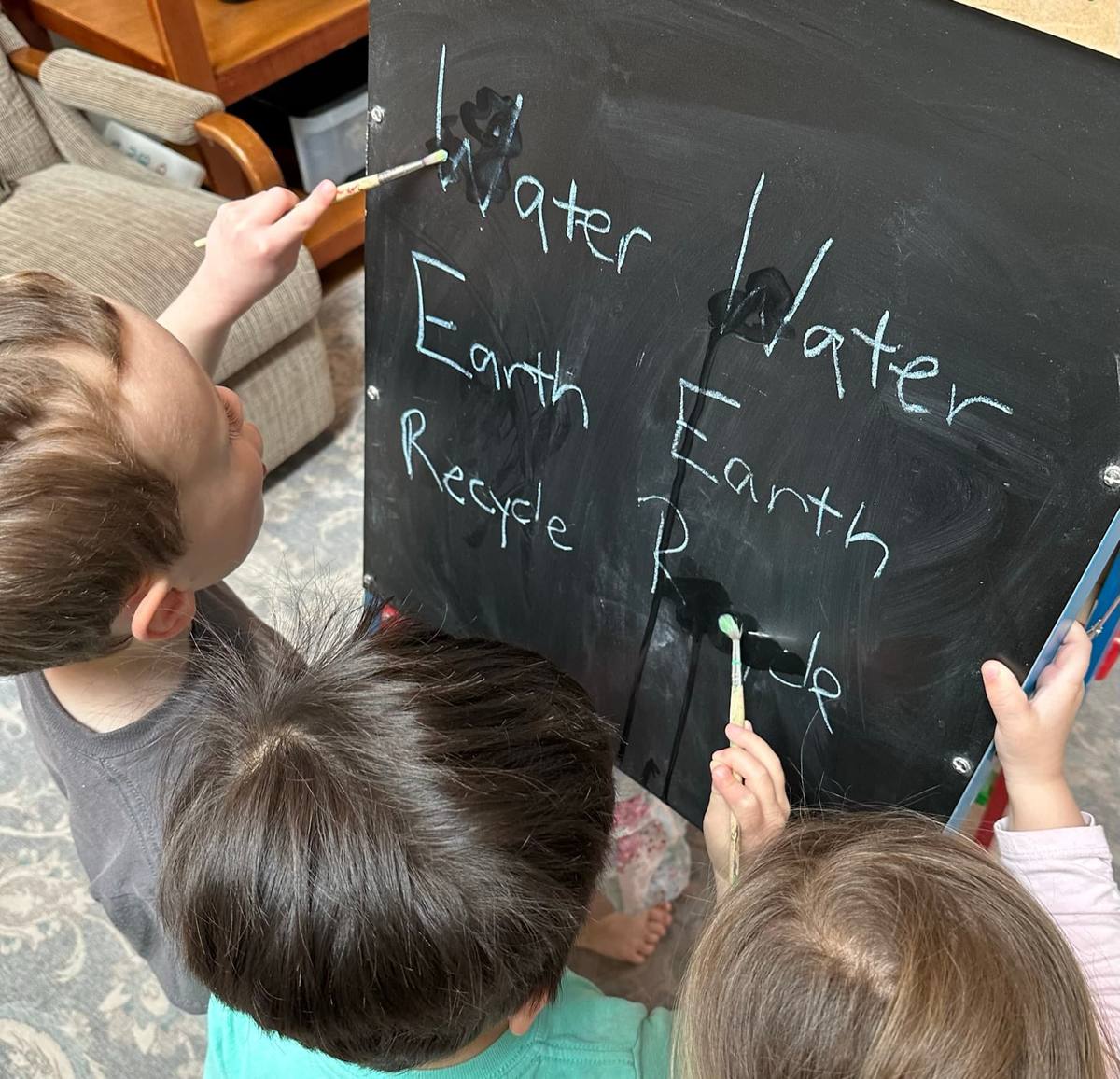 Children practicing writing on a chalkboard